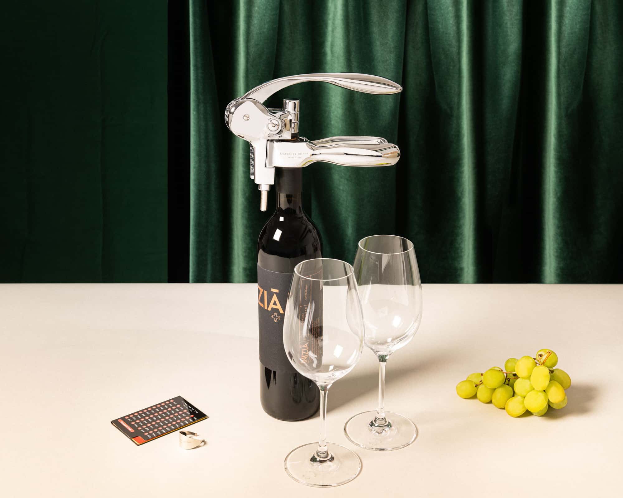 Tire-bouchon à levier Oeno Box Sommelier sur une bouteille de vin rouge avec les verres Exploreur Oenologie, Wine Ring, et carte des millésimes